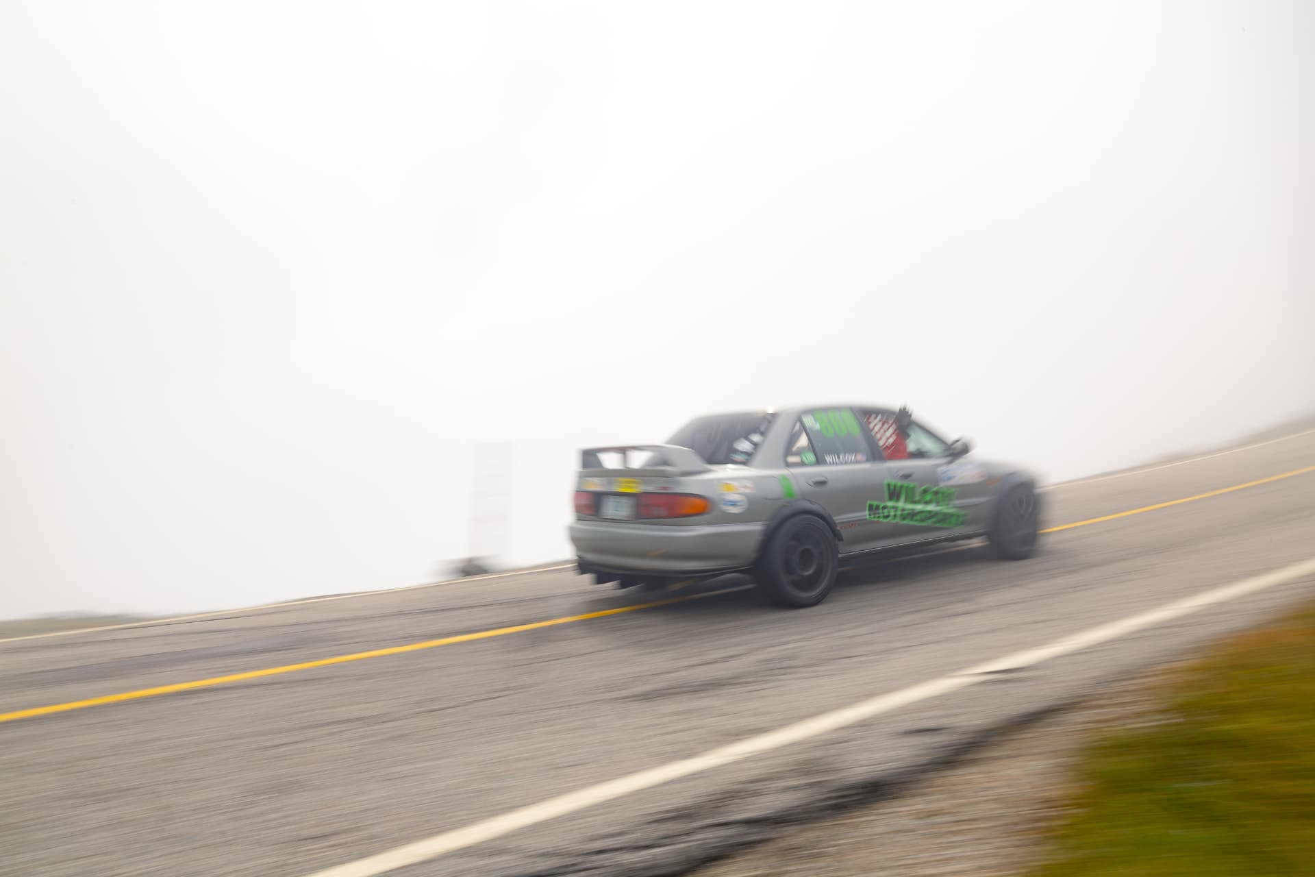 The Wilcox Motorsports Evolution disappearing into the clouds above the treeline